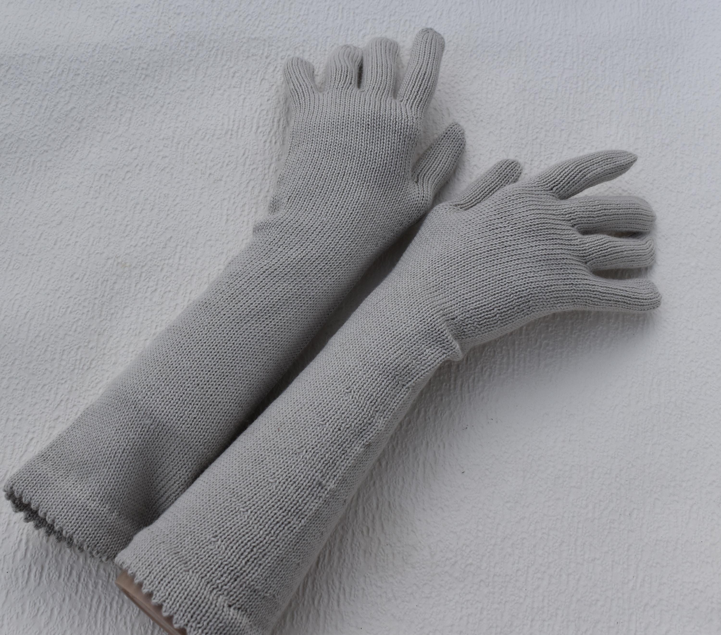 Pair of gray gloves on a light gray background