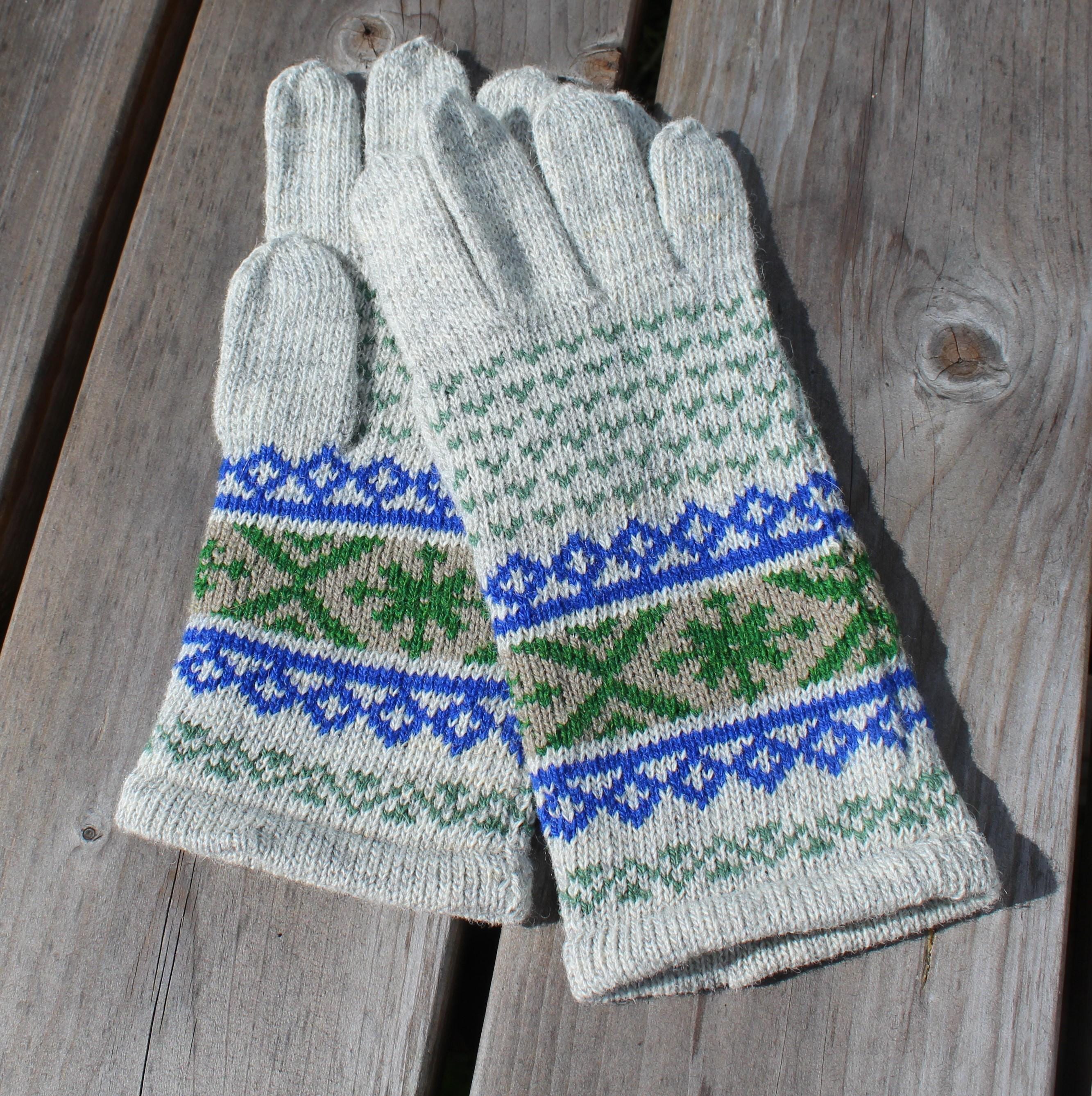Pair of gray gloves with blue and green patterns on a wooden surface