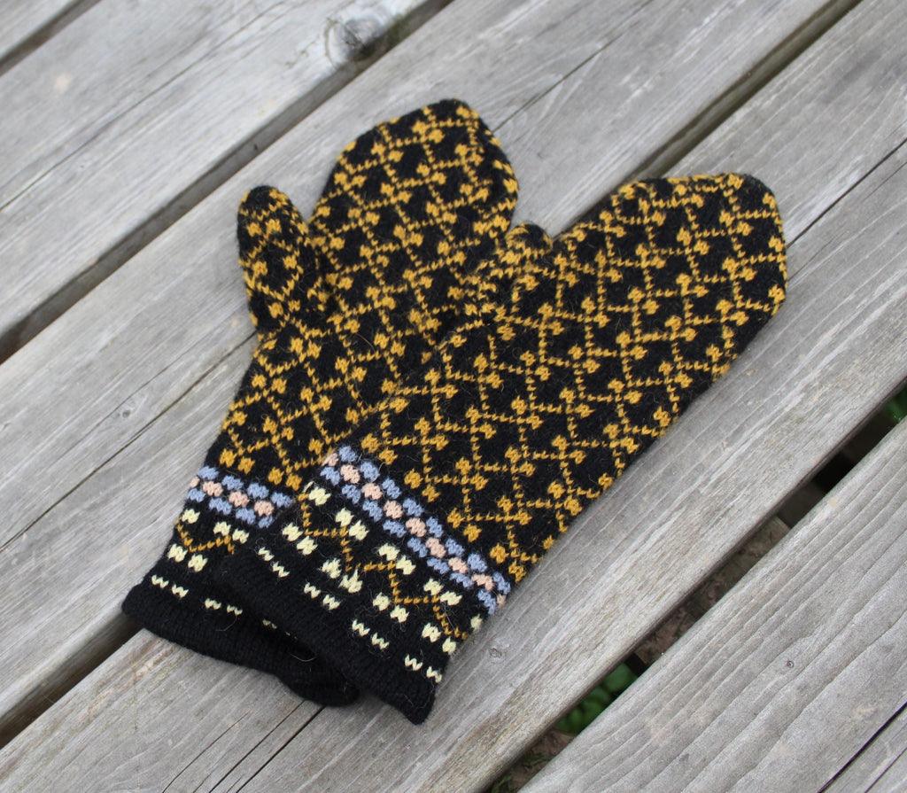 Knitted mittens with a geometric pattern on a wooden surface
