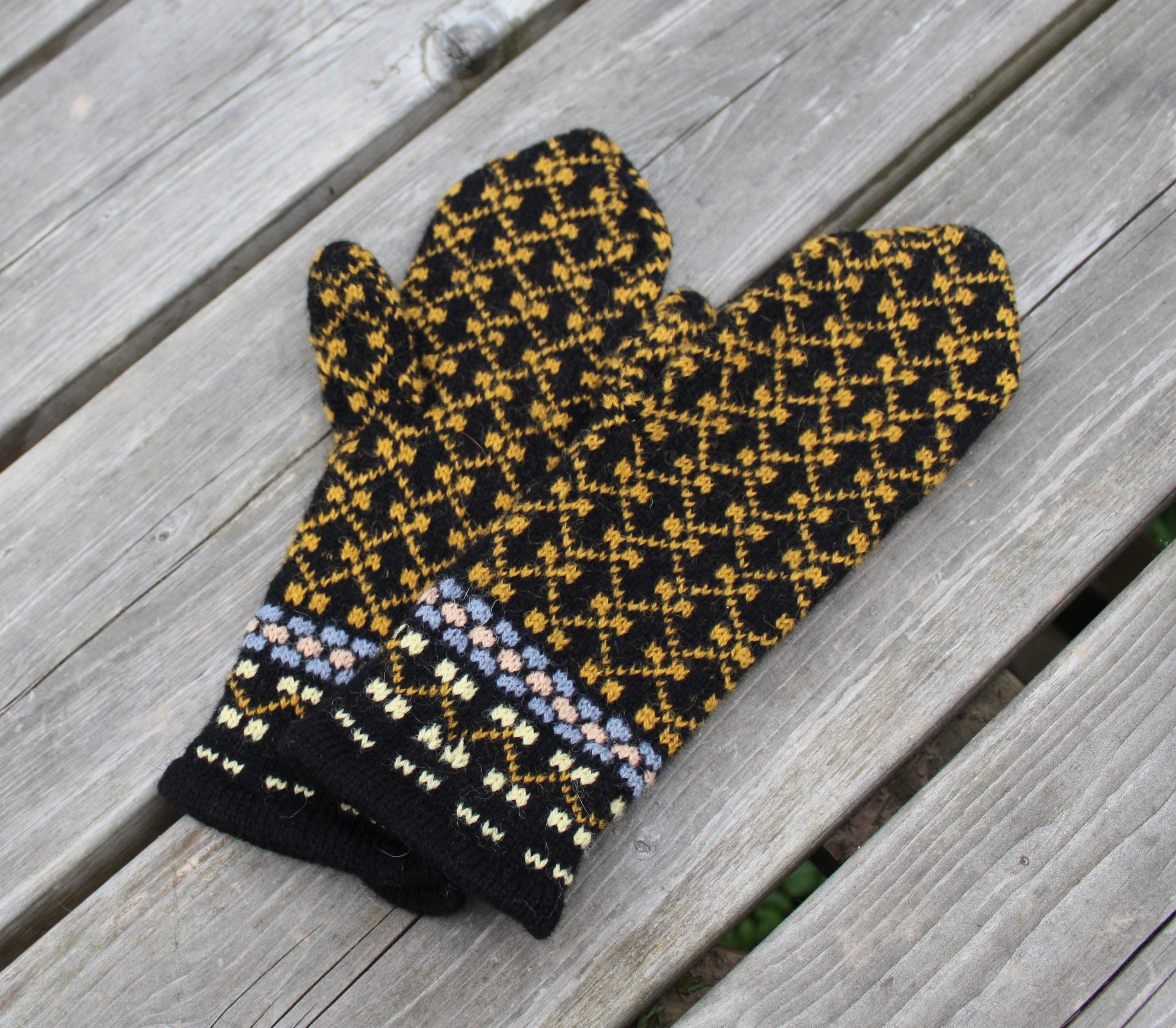 Knitted mittens with a geometric pattern on a wooden surface