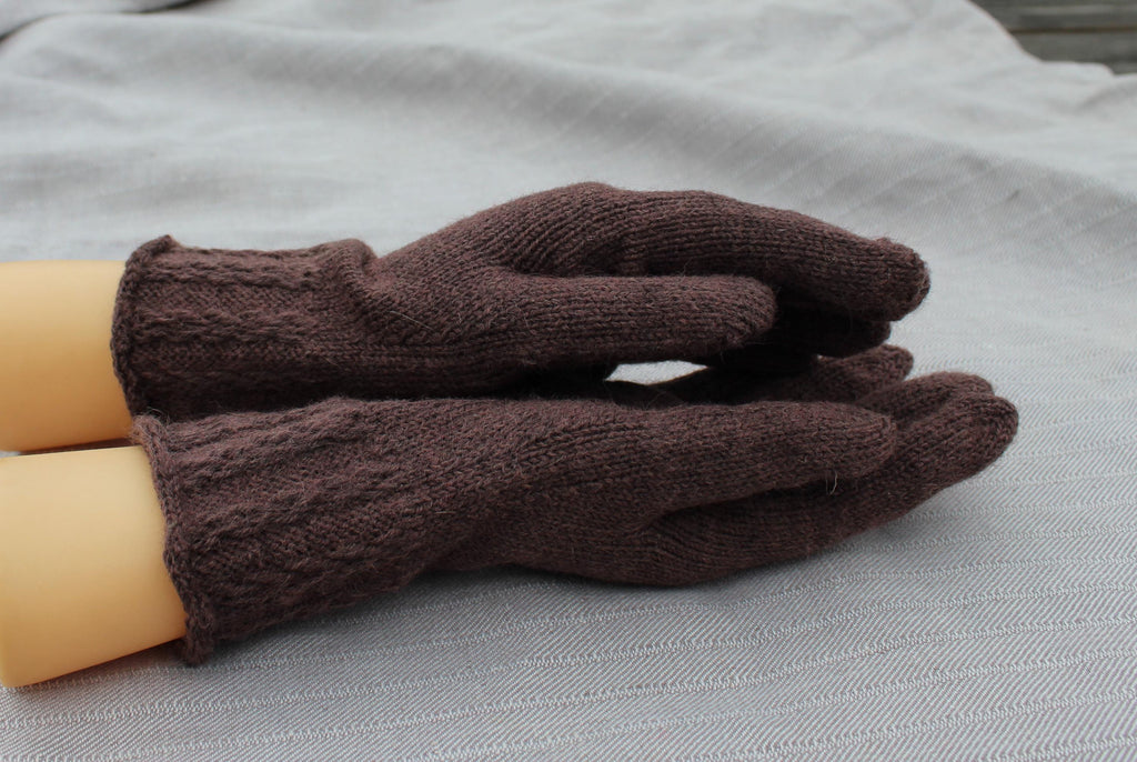 Pair of brown gloves on a light gray surface