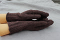 Pair of brown gloves on a light gray surface
