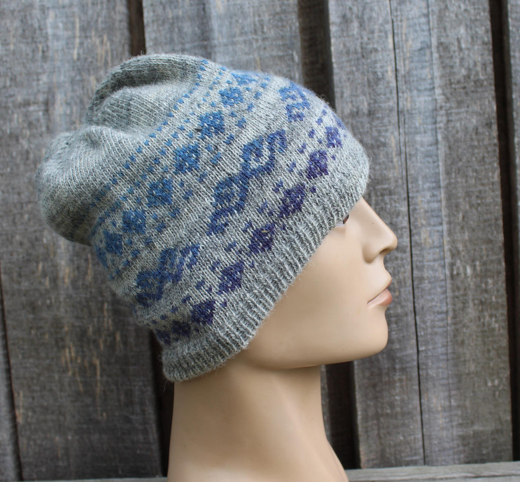 Gray knit beanie with blue floral pattern on a mannequin head against a wooden background