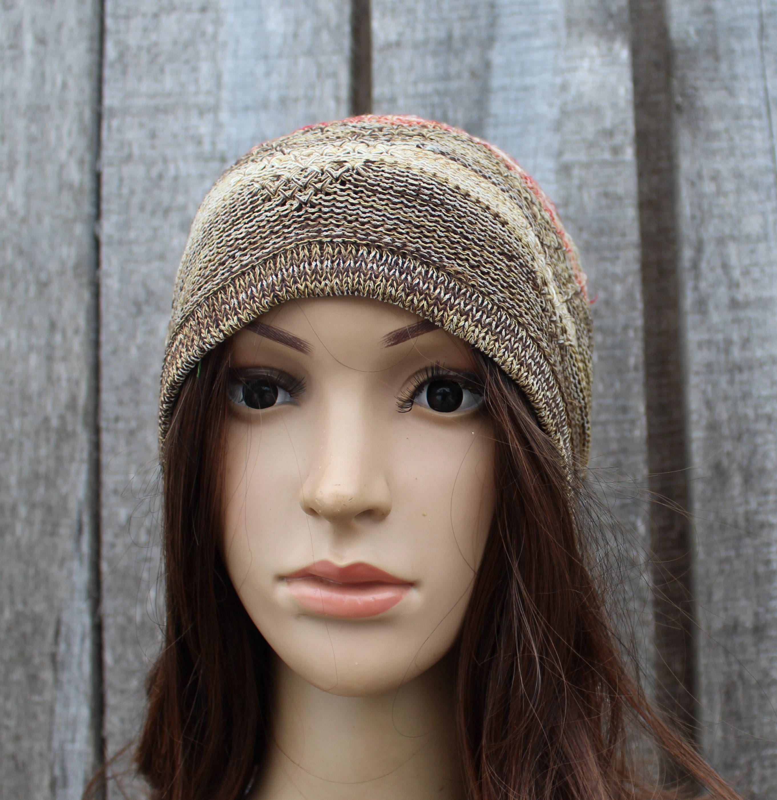 Knitted beanie on a mannequin head against a wooden panel background