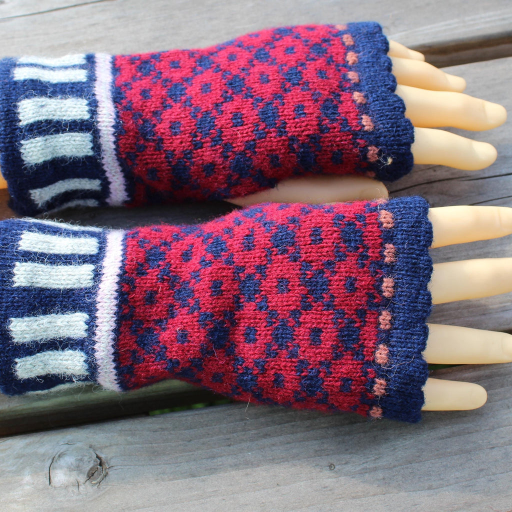 Pair of red and blue patterned fingerless gloves on a wooden surface