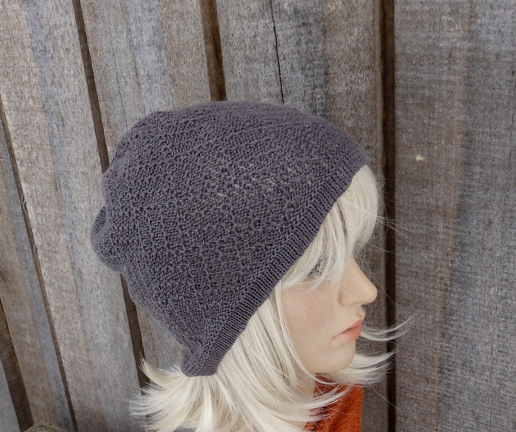Gray knit beanie on a mannequin head against a wooden background
