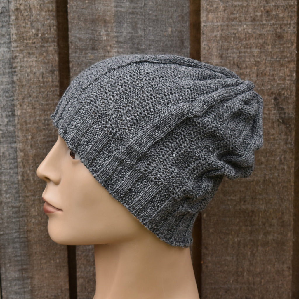 Gray knit beanie on a mannequin head against a brown textured background