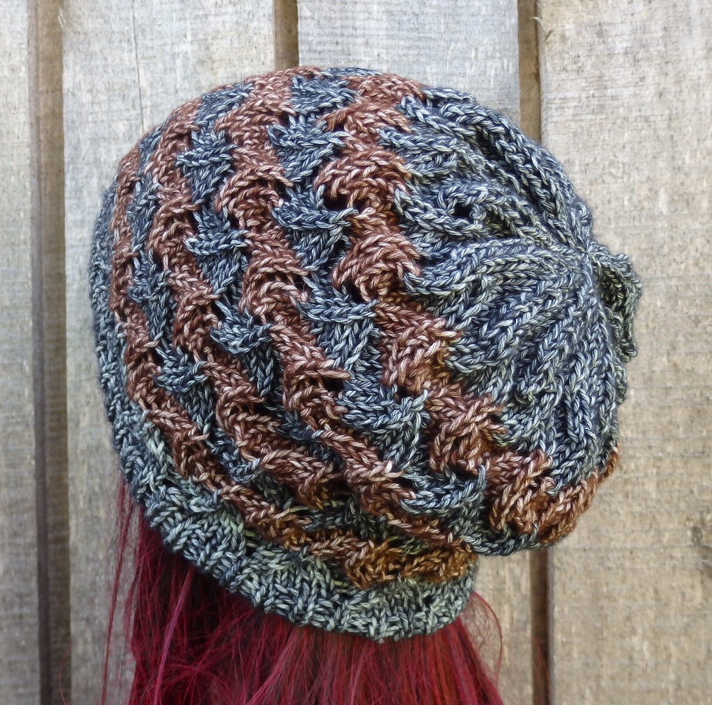 Knitted hat with brown and blue pattern on a wooden background
