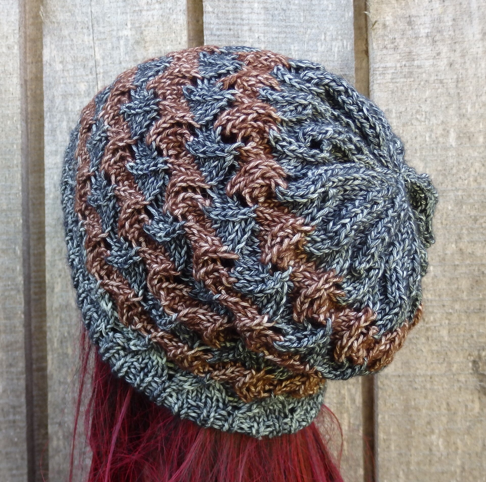 Knitted hat with brown and blue pattern on a wooden background