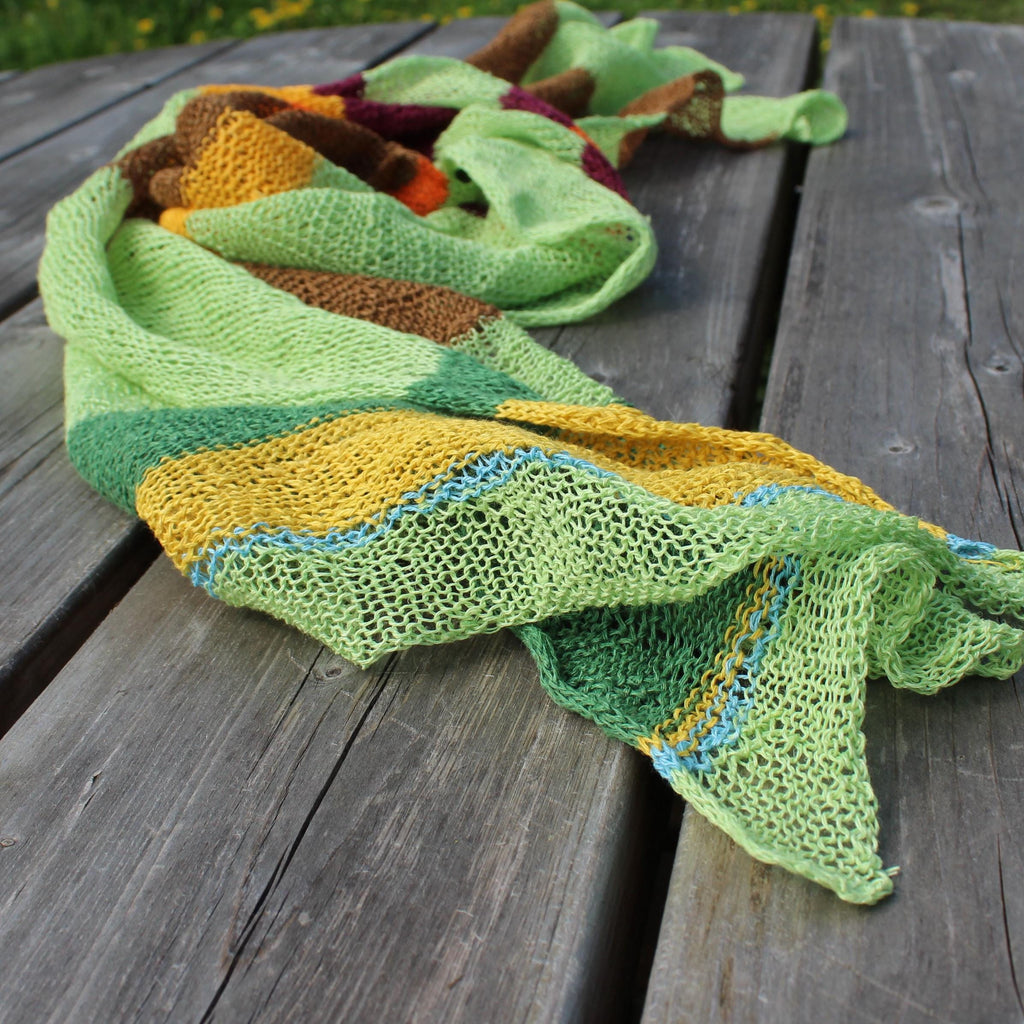 Colorful knitted scarf on a wooden surface
