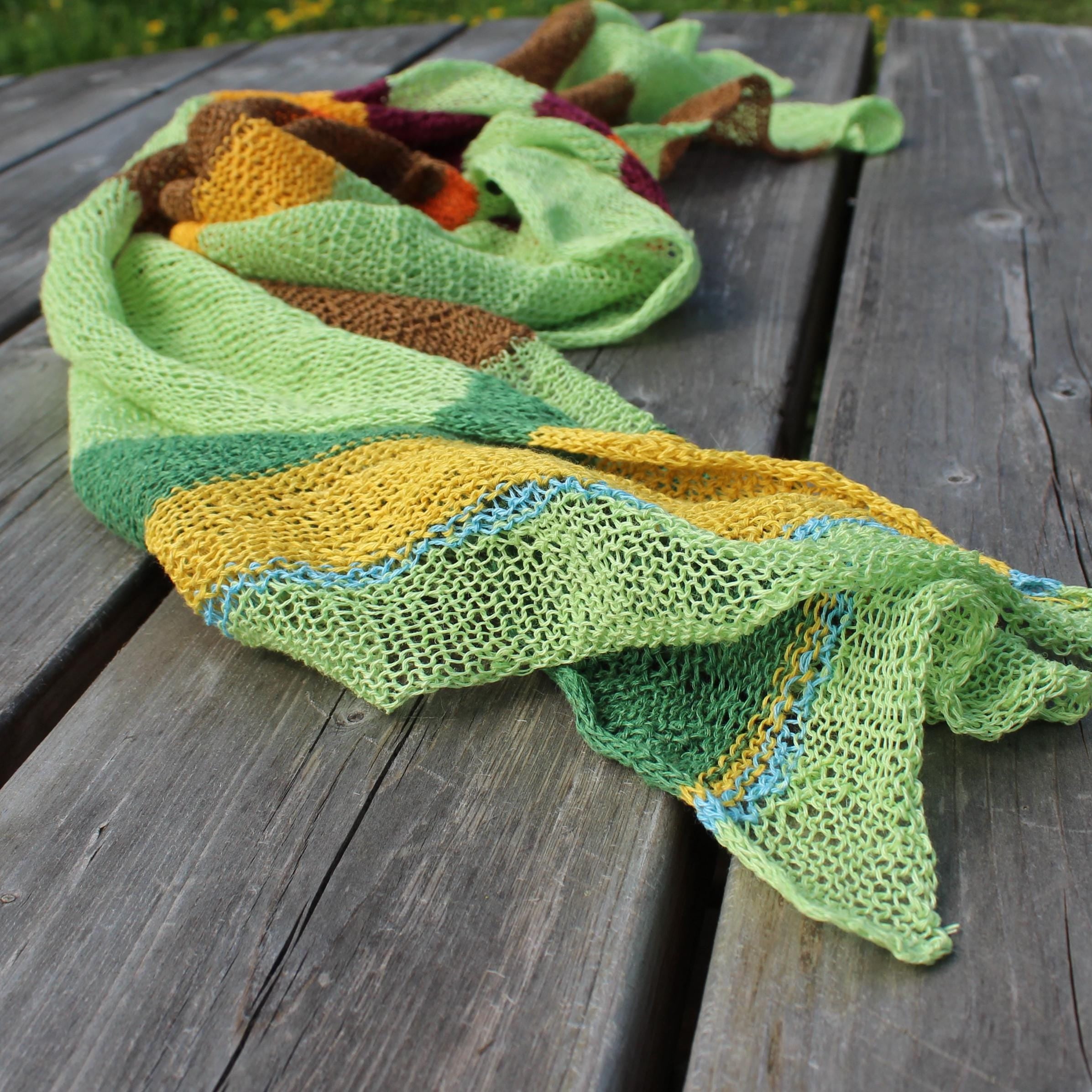Colorful knitted scarf on a wooden surface