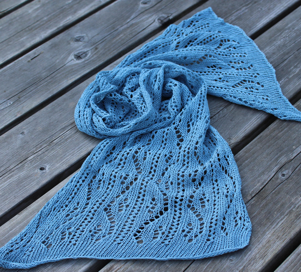 Blue knitted shawl on a wooden surface