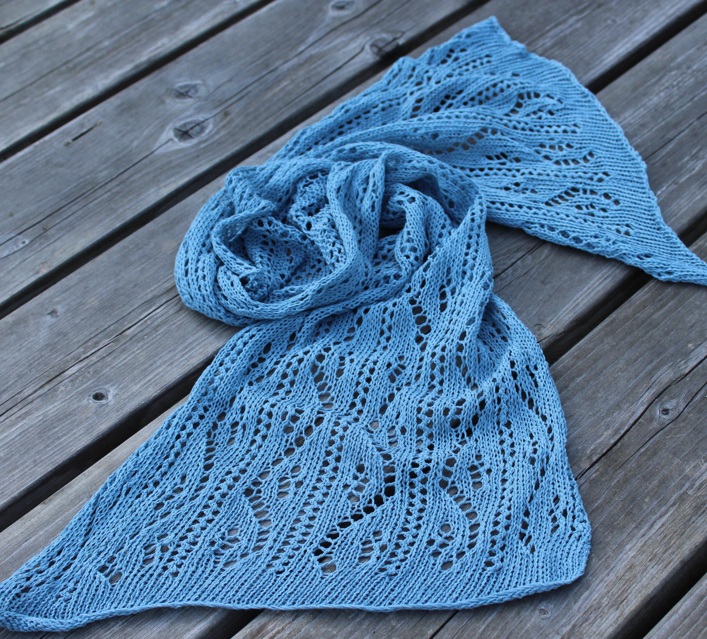 Blue knitted shawl on a wooden surface