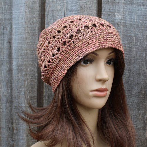 Mannequin head wearing a orange brown crochet hat against a wooden background