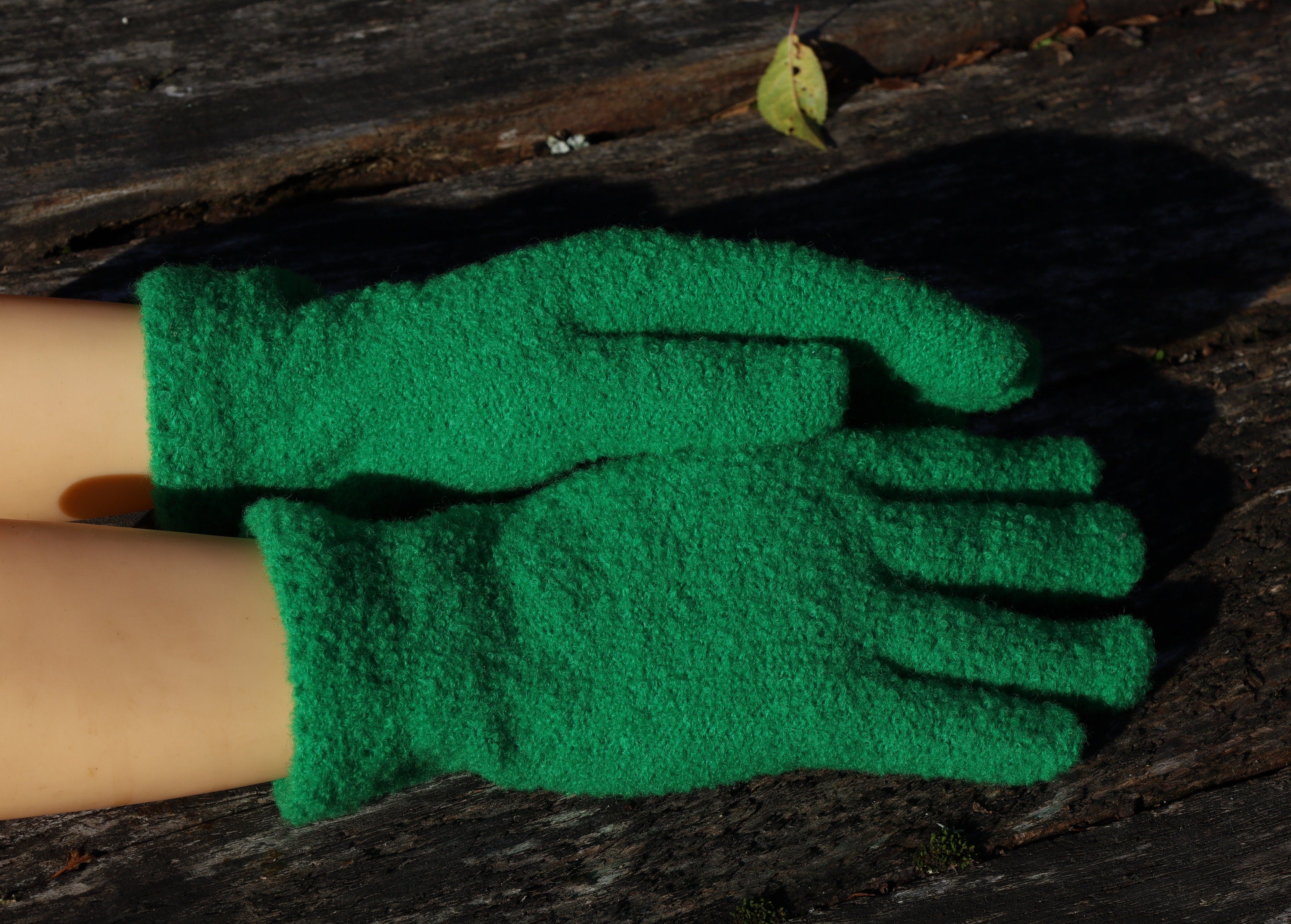 Green gardening gloves on a wooden surface