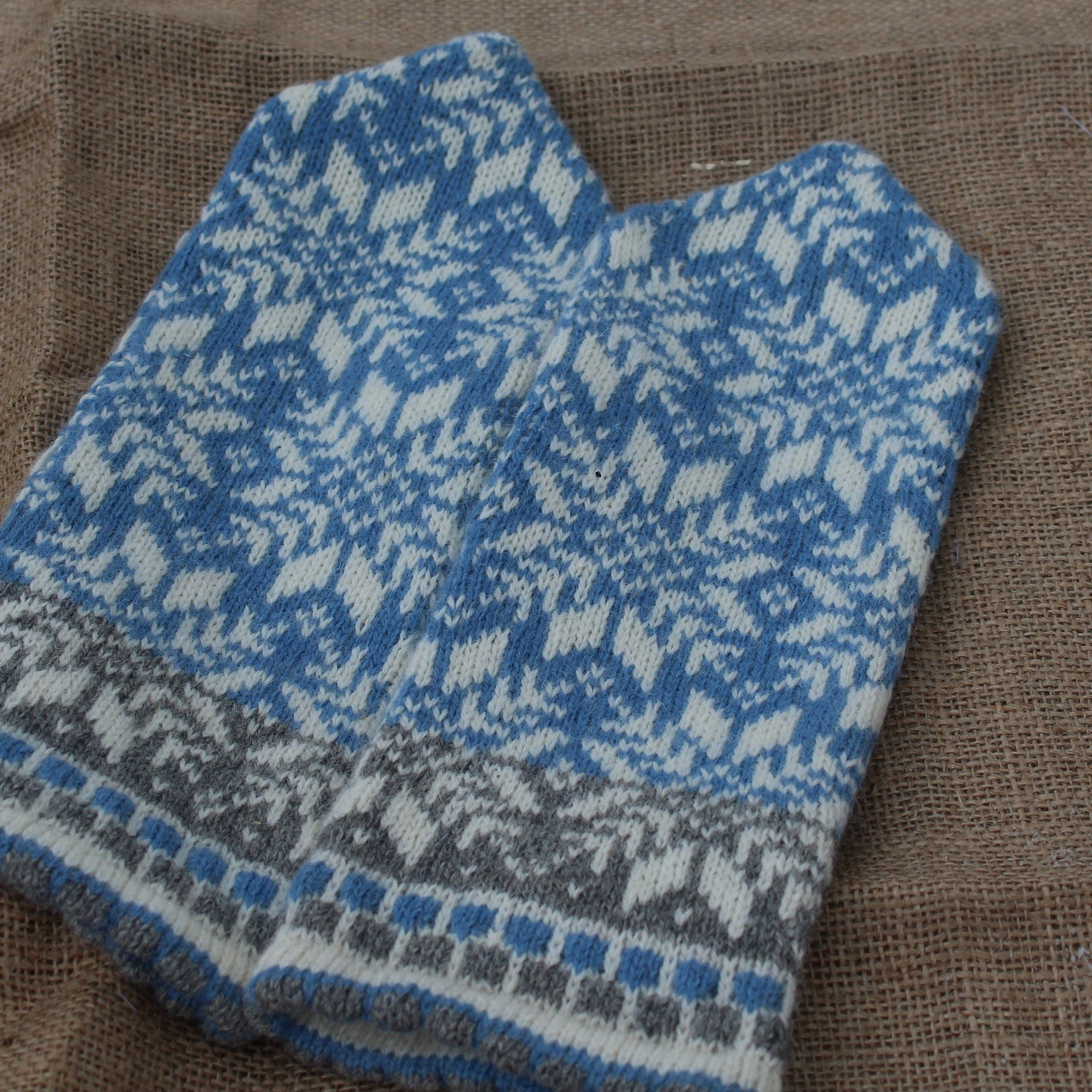 Knitted blue and gray patterned fabric on a brown textured background