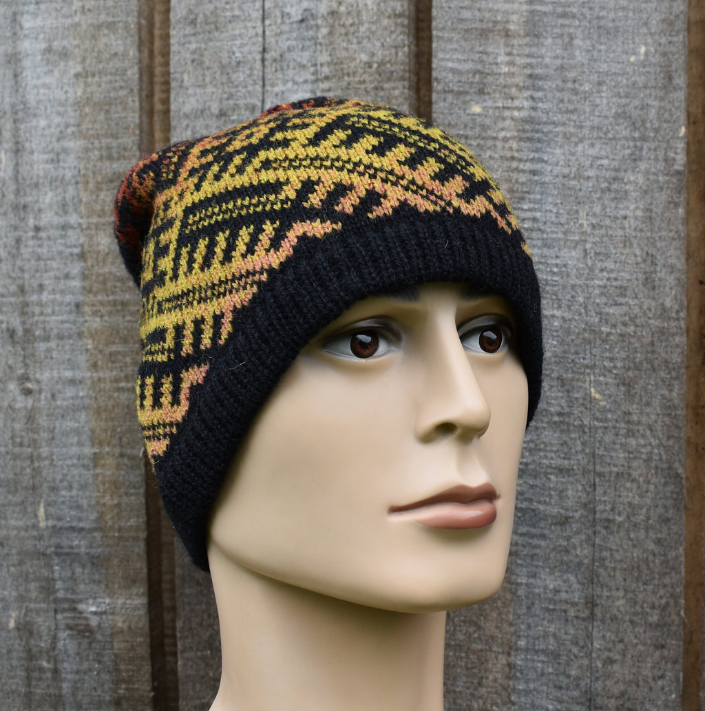 Knitted hat with a geometric pattern on a mannequin head against a wooden background