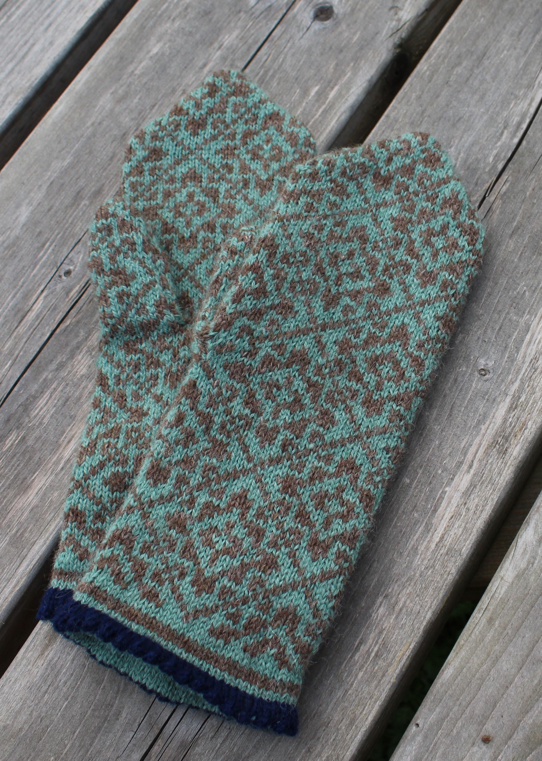 Knitted mitten with a pattern on a wooden surface