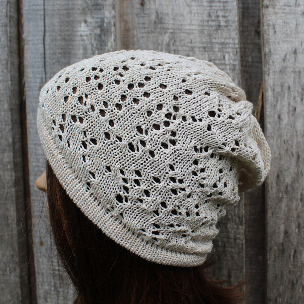 Knitted beige hat worn by a person against a wooden background