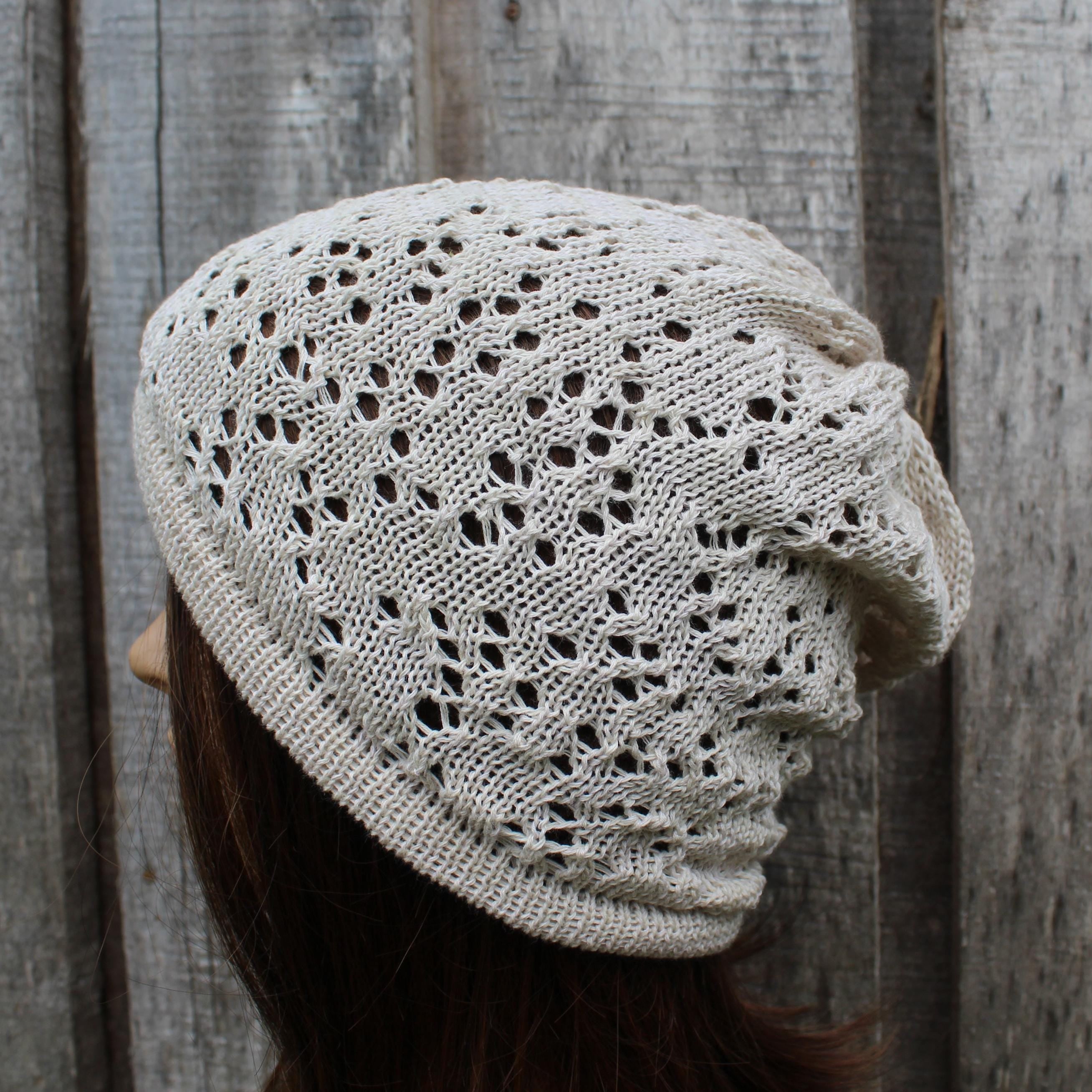 Knitted beige hat worn by a person against a wooden background
