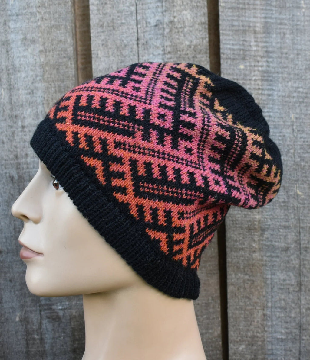 Knitted beanie with a geometric pattern on a mannequin head against a wooden background