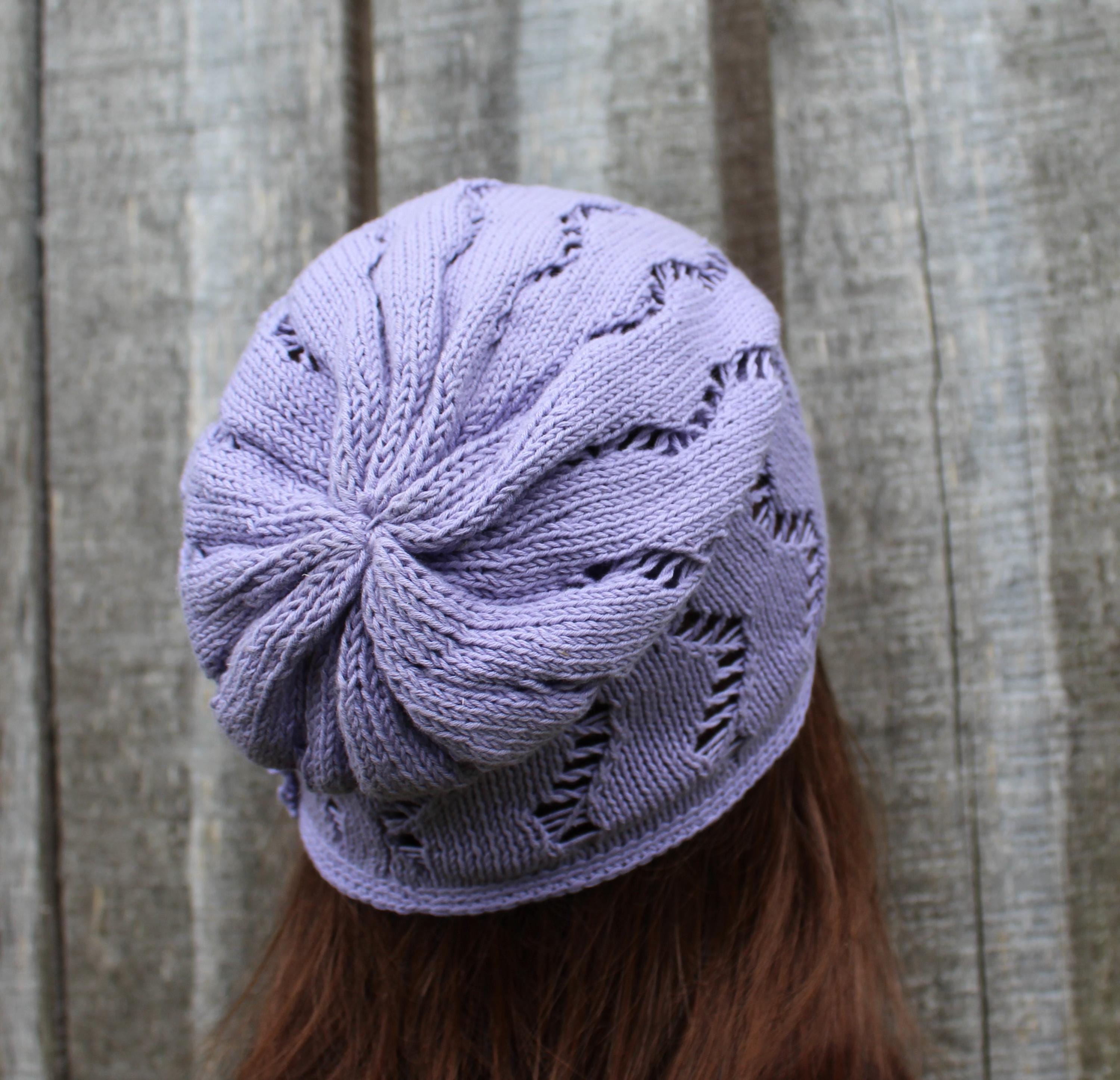 Purple knitted hat with star pattern worn by a person against a wooden background