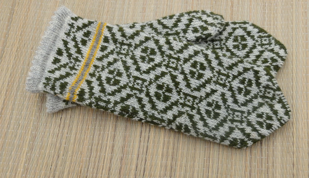 Pair of knitted gloves with a geometric pattern on a wooden surface