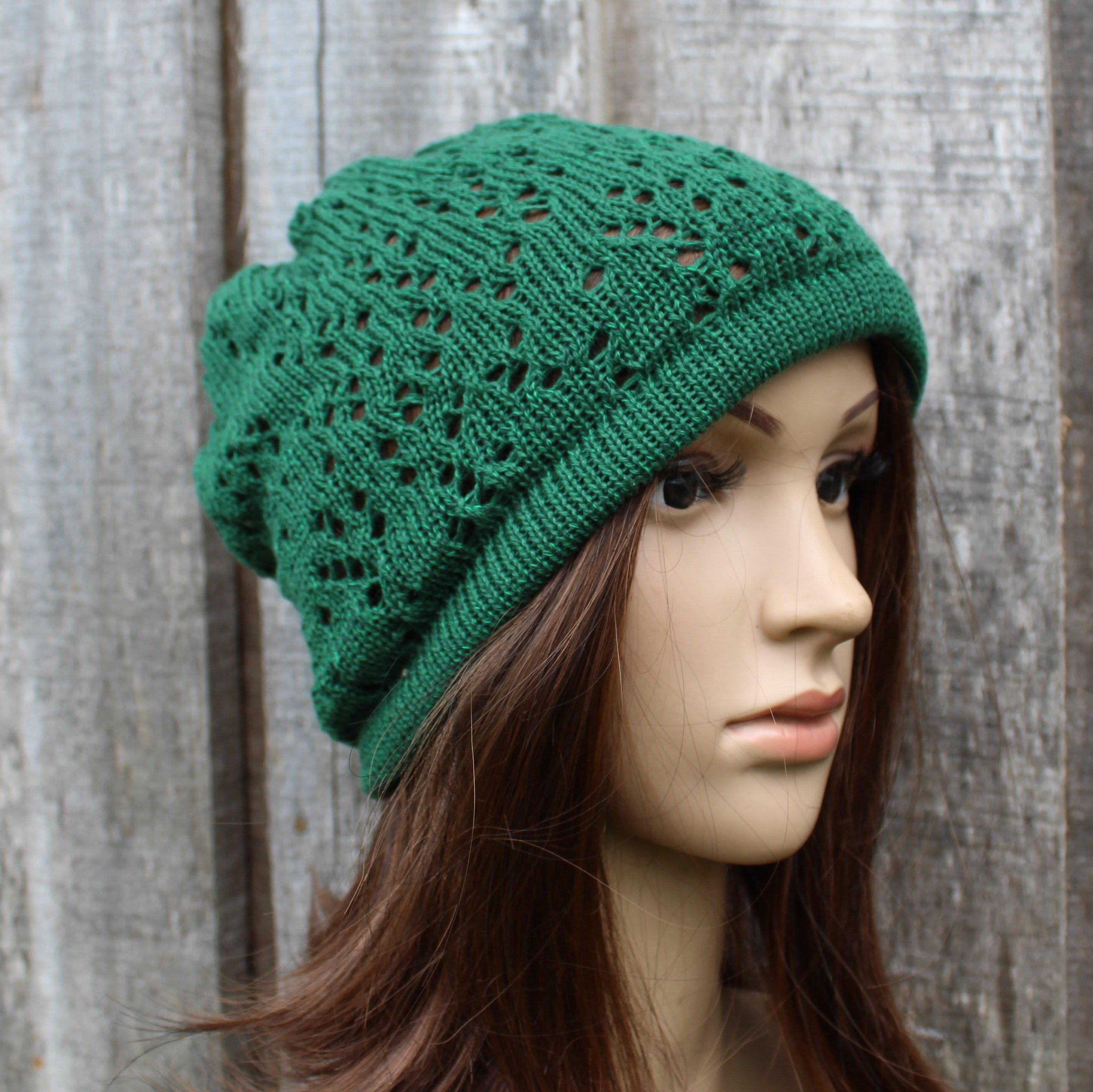 Green knitted hat on a mannequin head against a wooden background