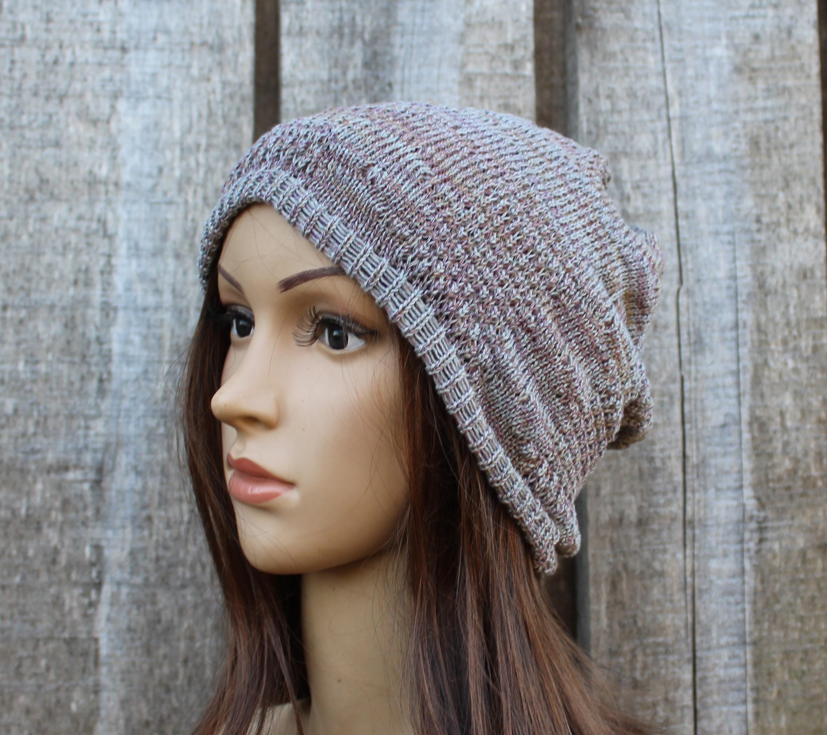 Knitted beanie on a mannequin head against a wooden background