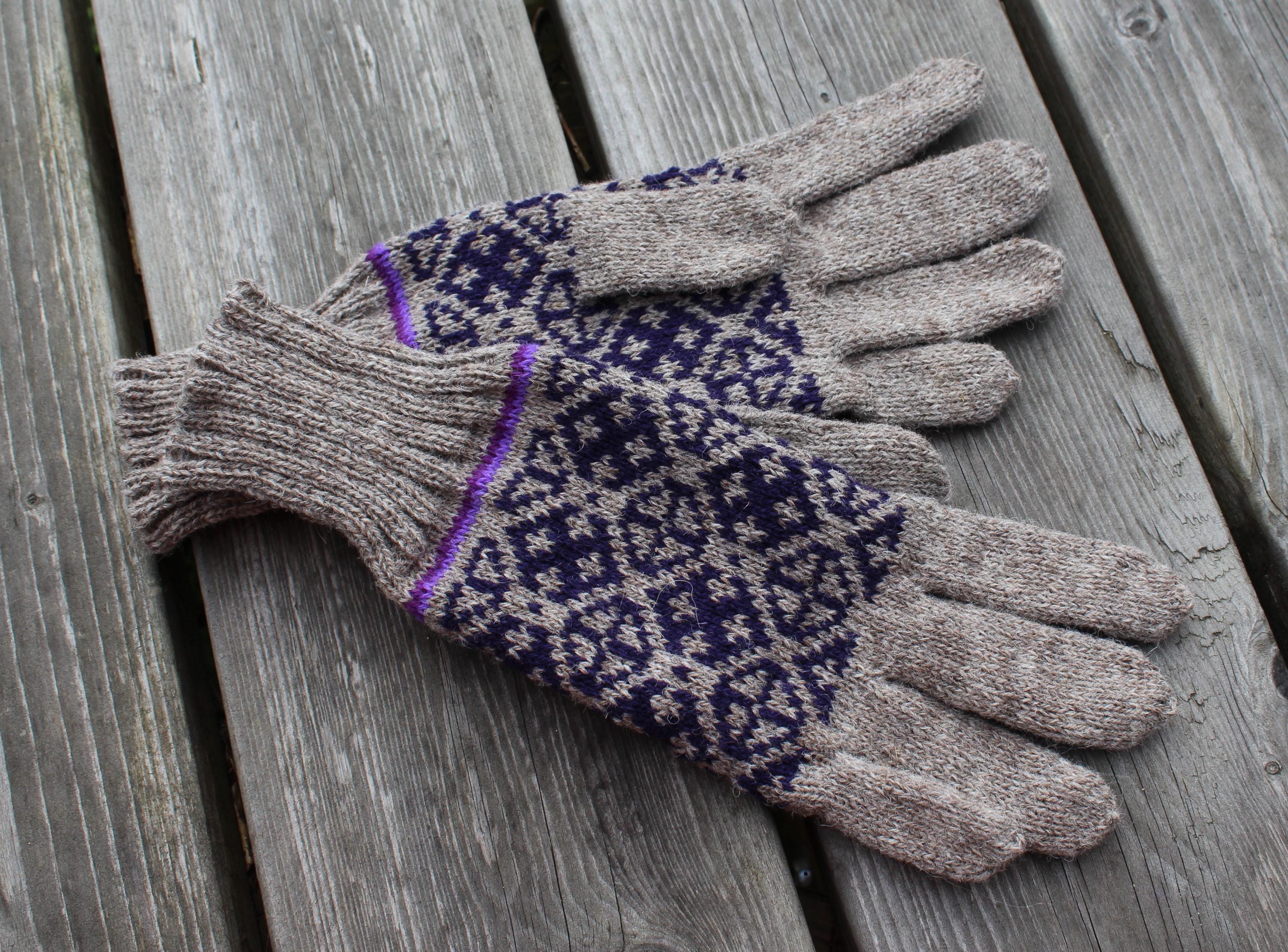 Pair of gloves with a pattern on a wooden surface