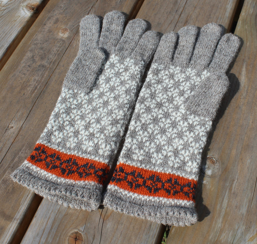 Pair of gray gloves with a patterned cuff on a wooden surface