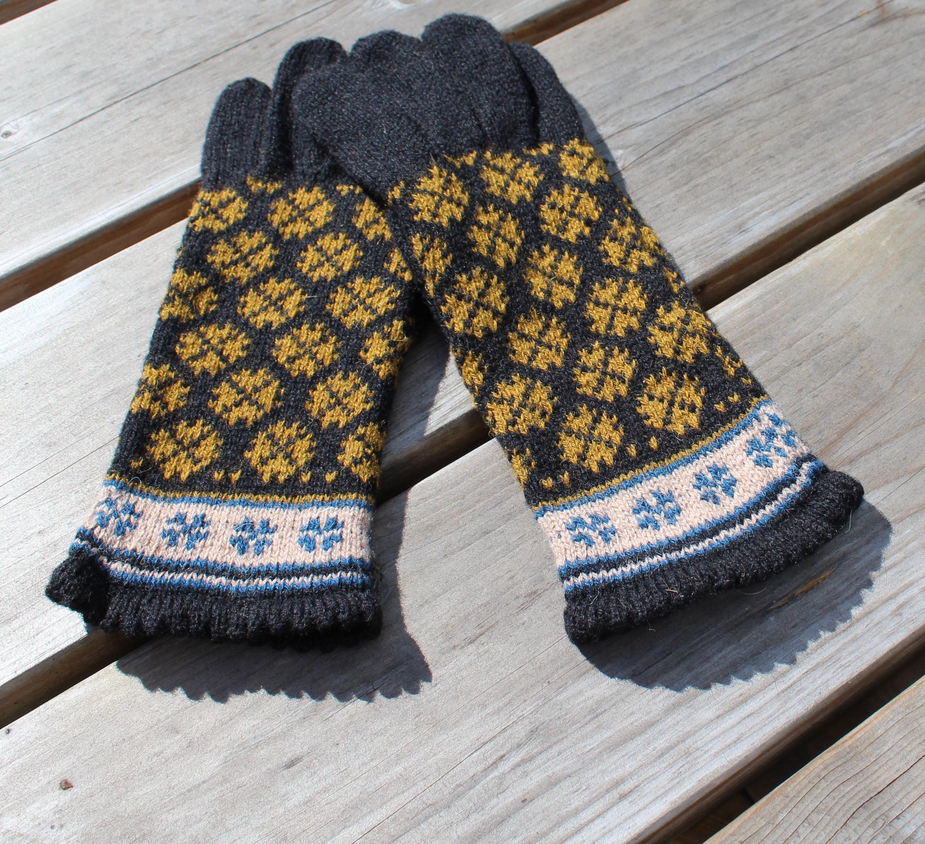 Pair of knitted gloves with a pattern on a wooden surface