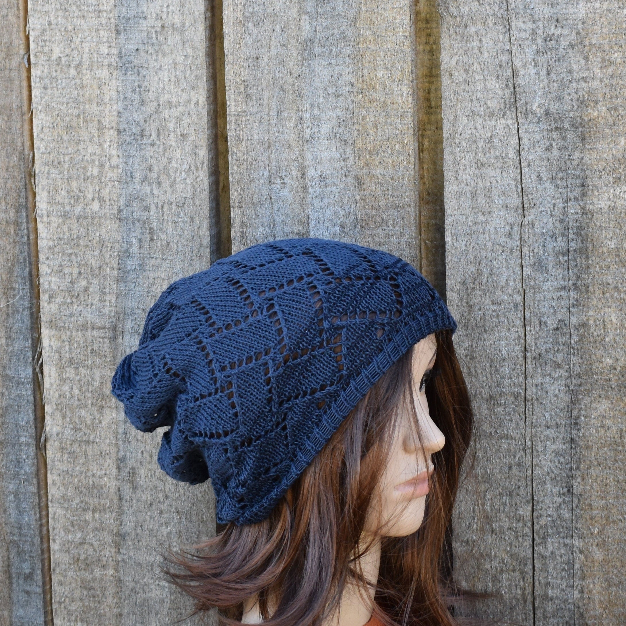 Person wearing a blue knitted hat against a wooden background