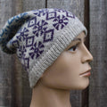 Knitted beanie with a pattern on a mannequin head against a wooden background