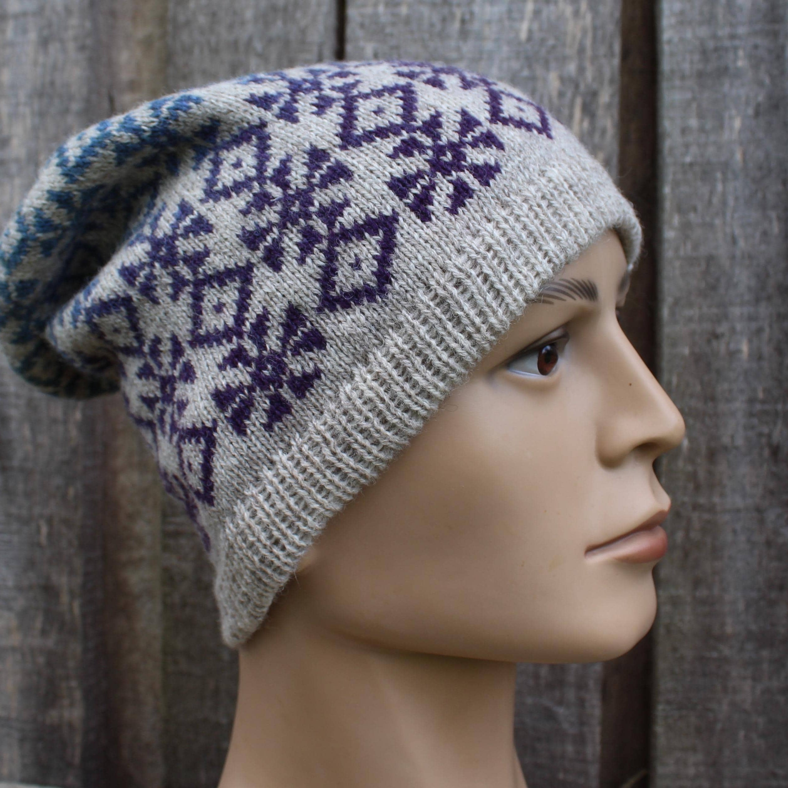 Knitted beanie with a pattern on a mannequin head against a wooden background