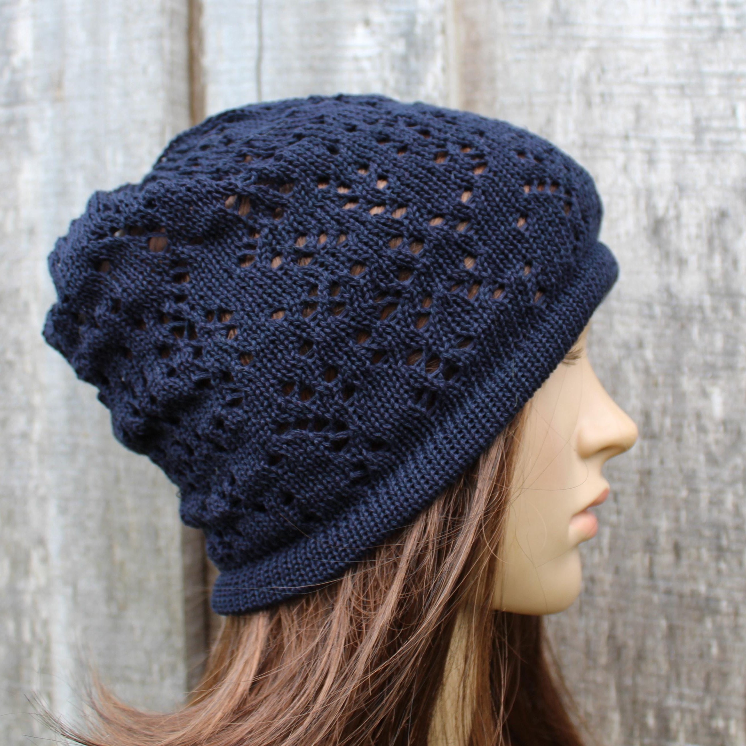 Navy blue knitted beanie on a mannequin head against a wooden background