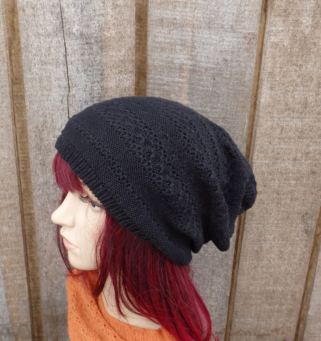 Person wearing a black knit beanie against a wooden background
