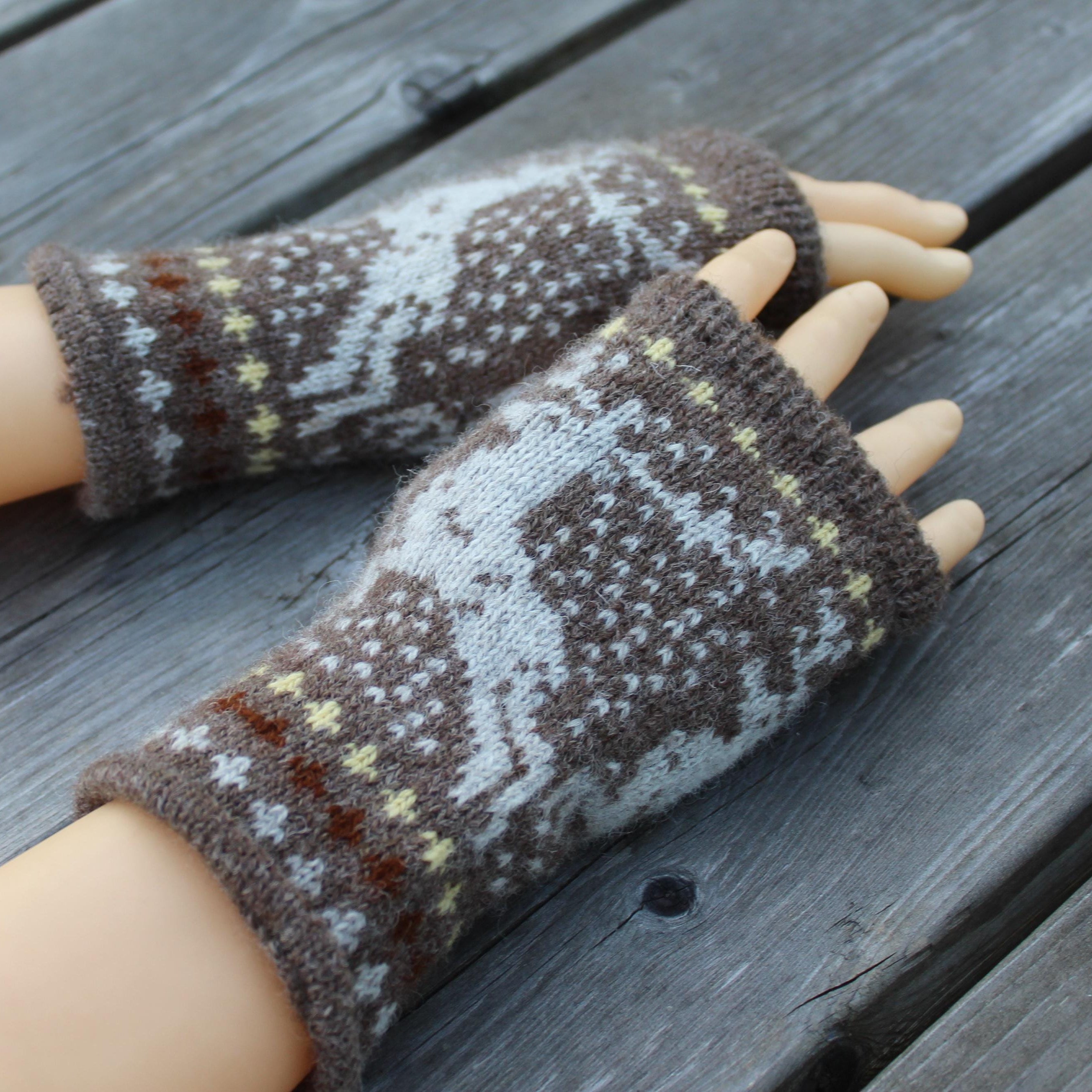 Pair of patterned fingerless gloves on a wooden surface