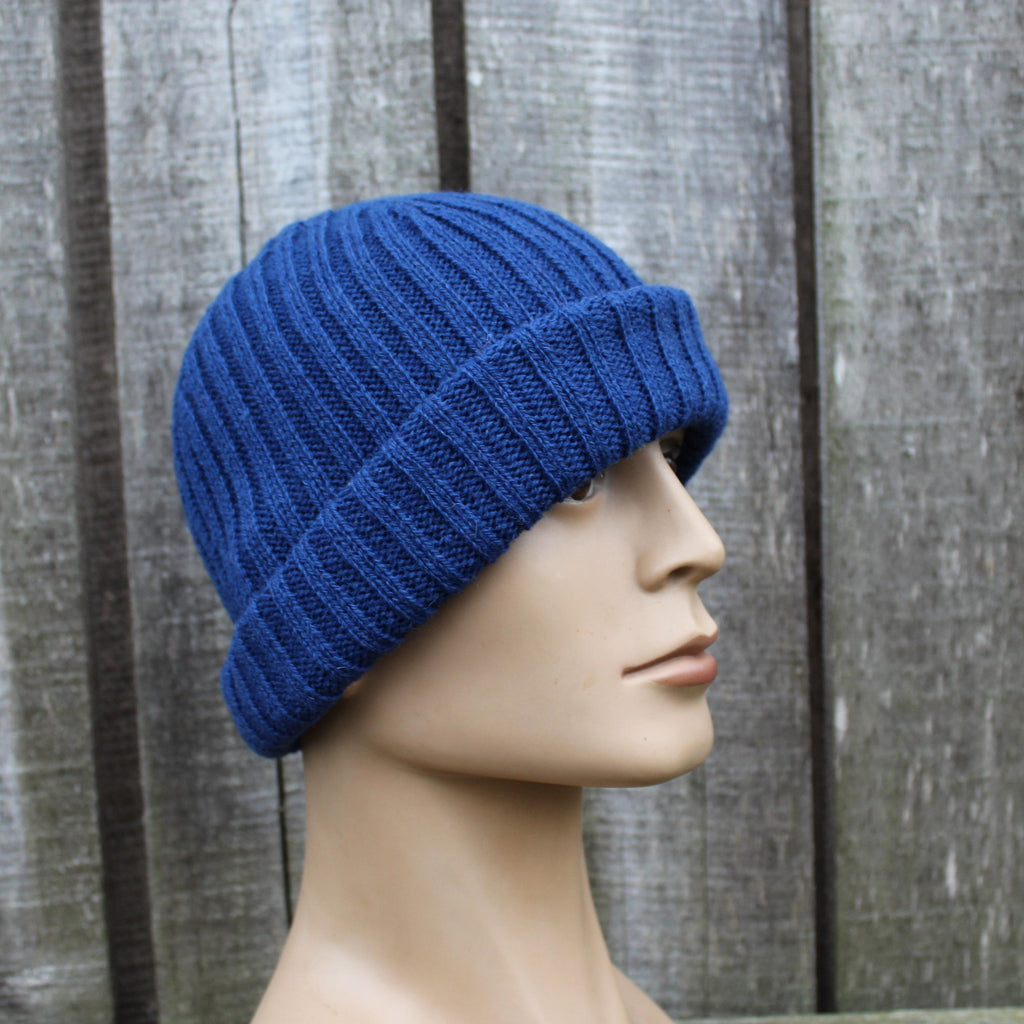 Blue knitted beanie on a mannequin head against a wooden background