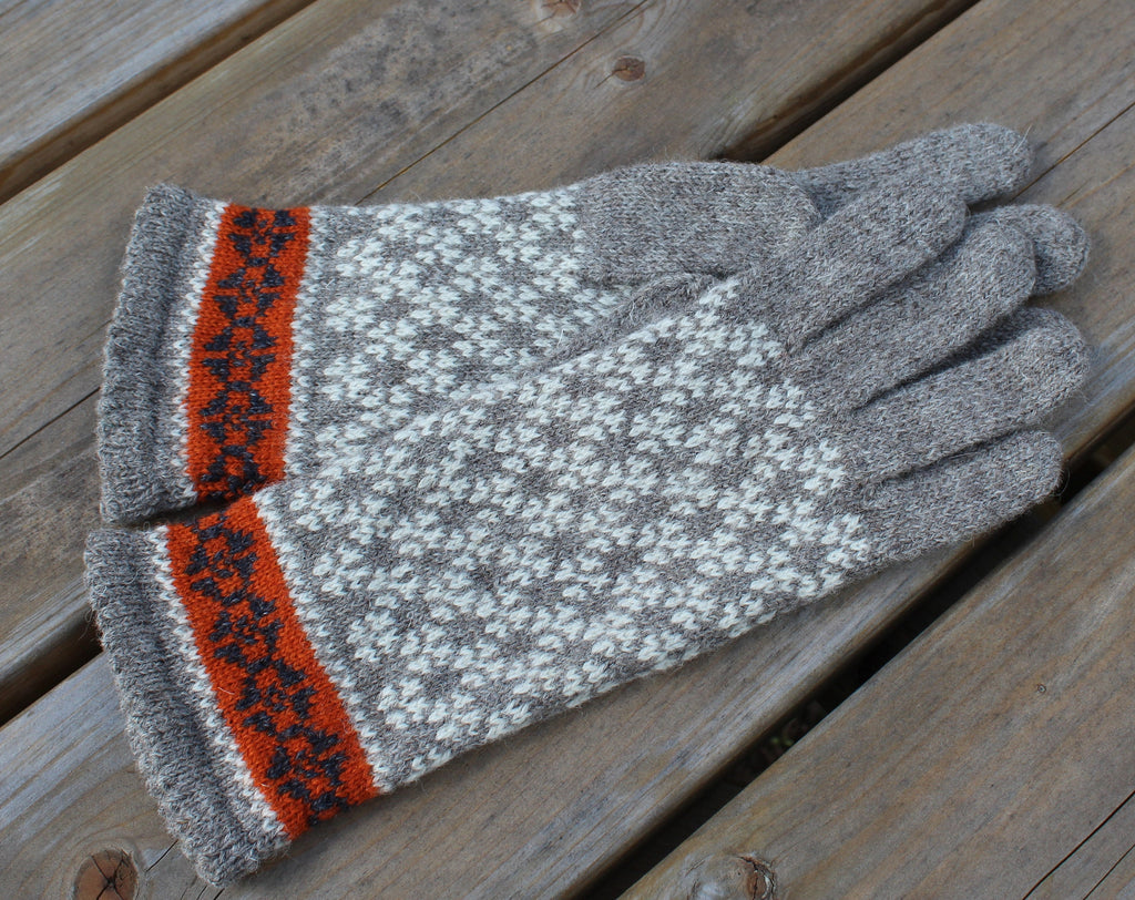 Gray glove with orange and black pattern on a wooden surface
