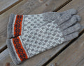 Gray glove with orange and black pattern on a wooden surface