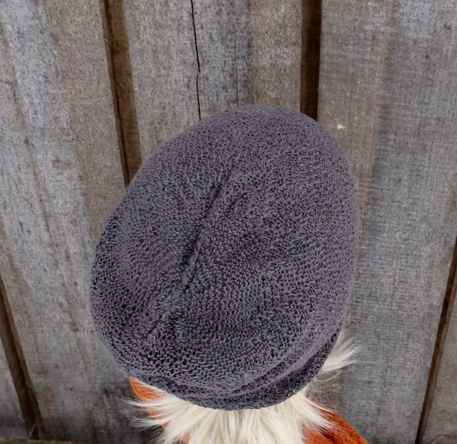 Textured gray knit cap on a wooden surface