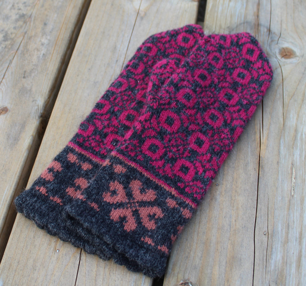 Pair of patterned mittens on a wooden surface