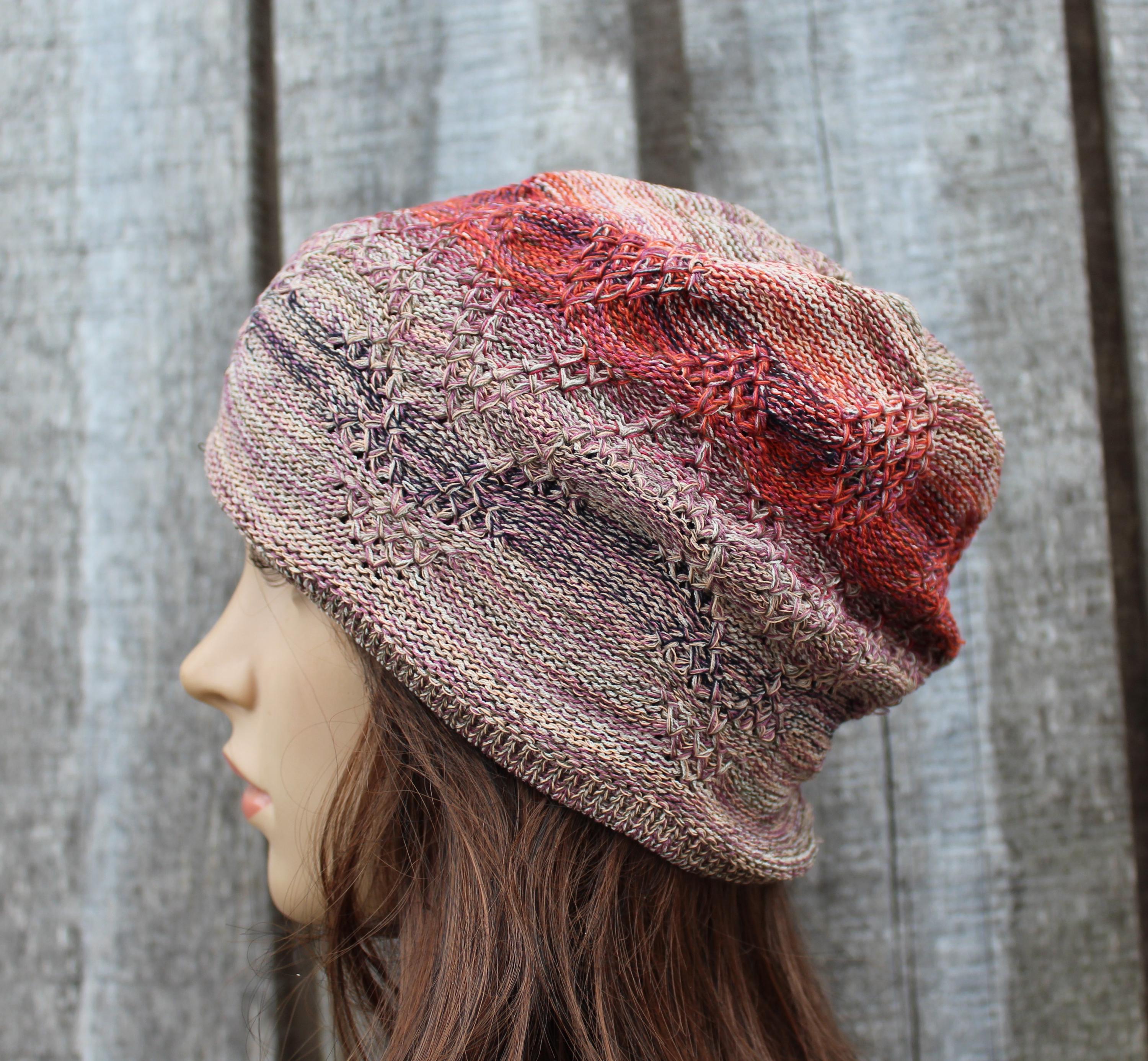 Knitted hat with a gradient pattern worn by a person against a wooden background