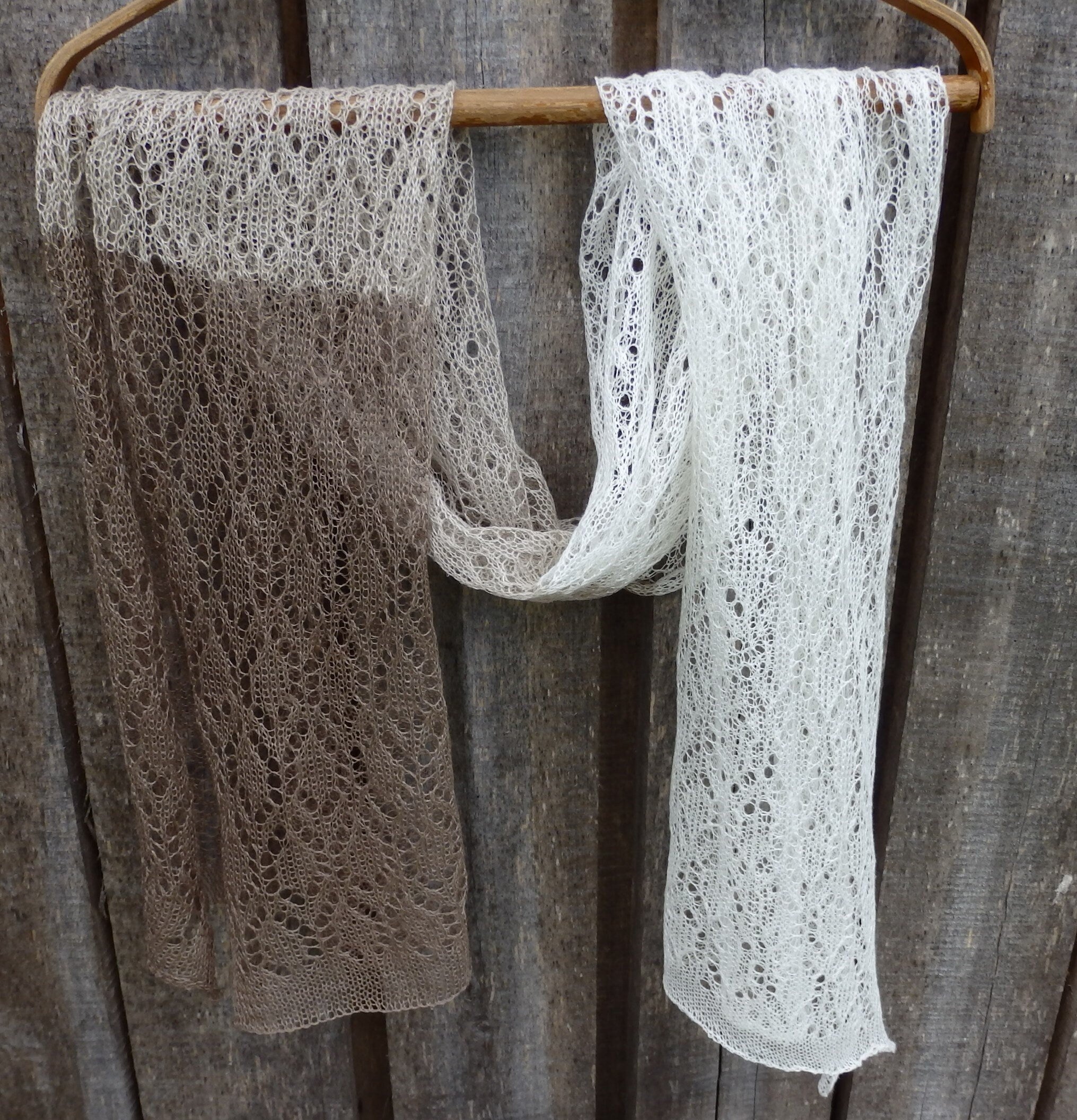 lace shawl ,hanging on a wooden rack against a rustic wooden background.