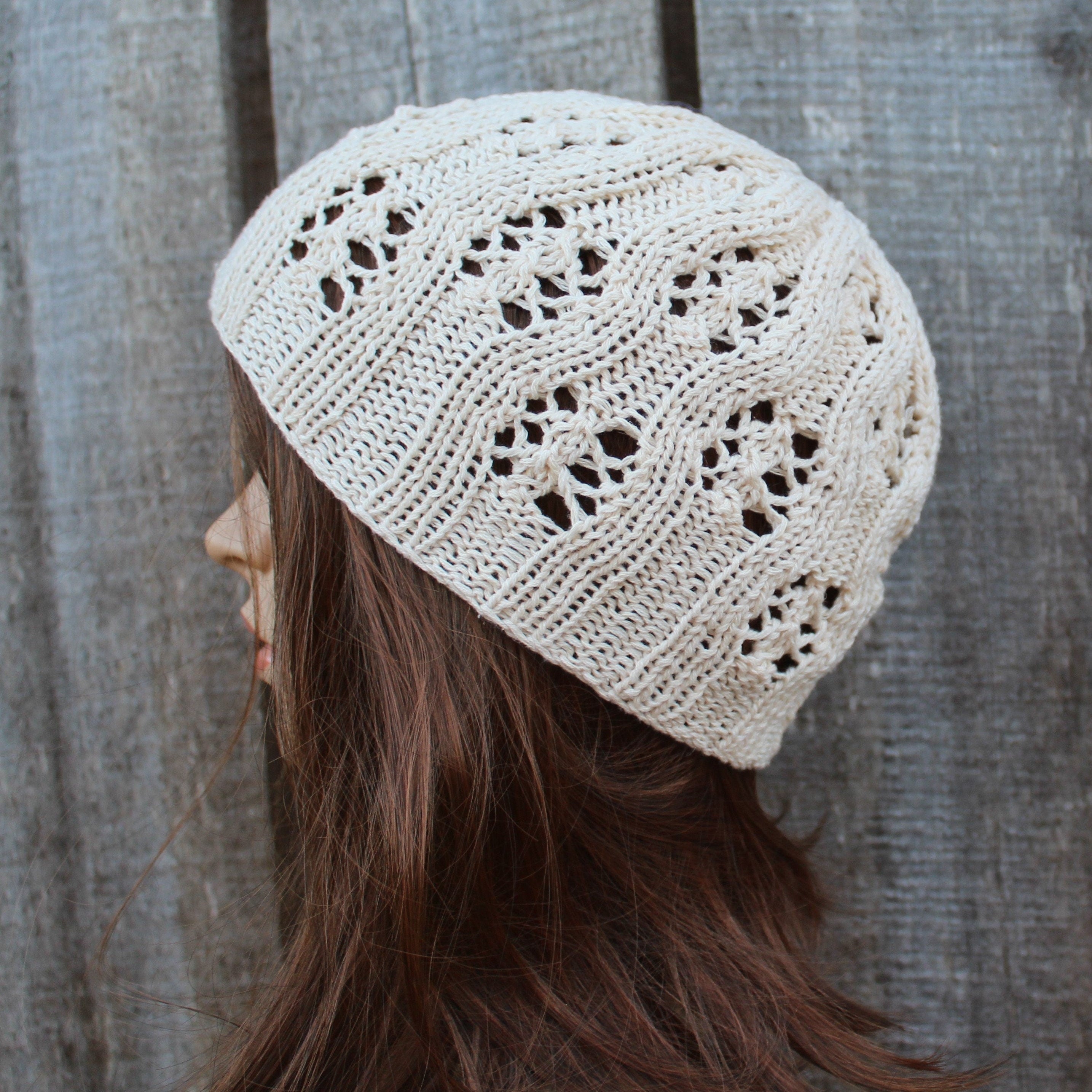 Beige knitted beanie worn by a person against a wooden background