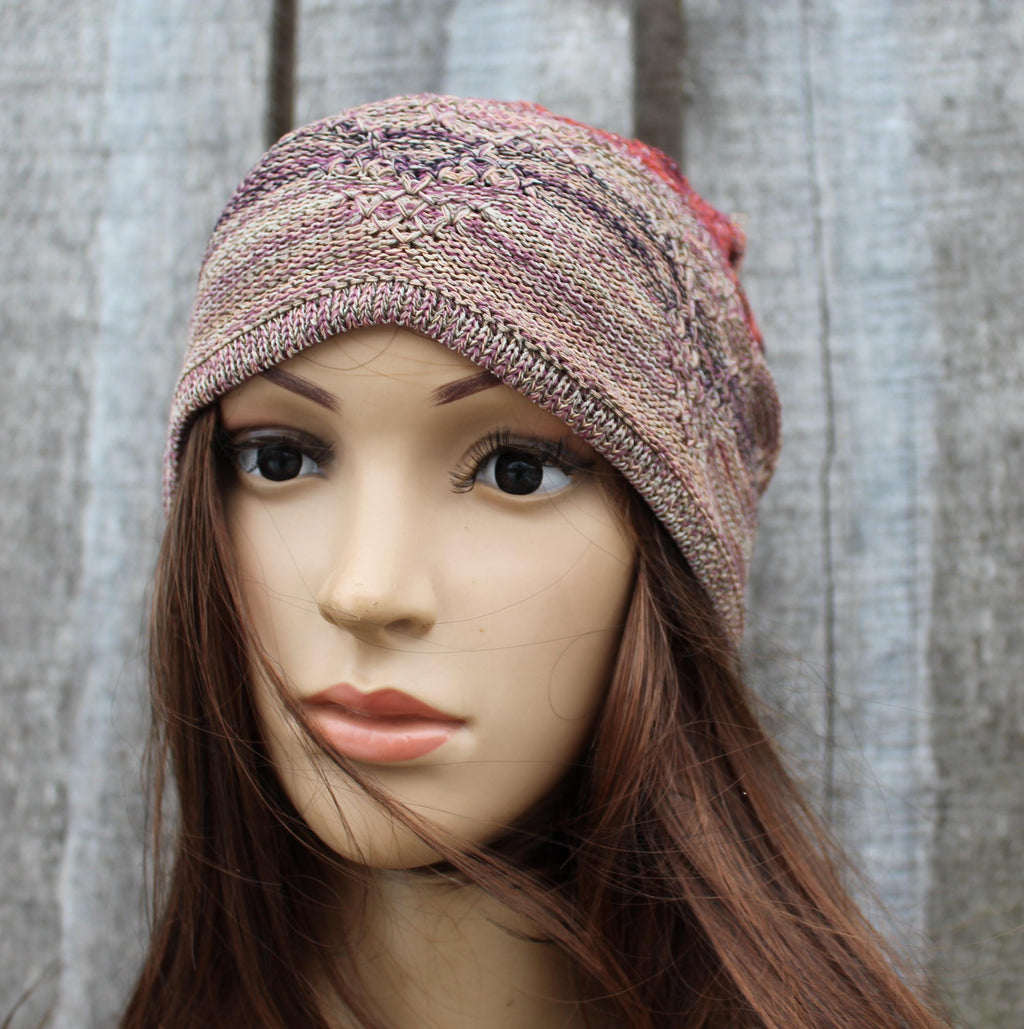 Mannequin head wearing a knitted multicolored headband against a textured gray background
