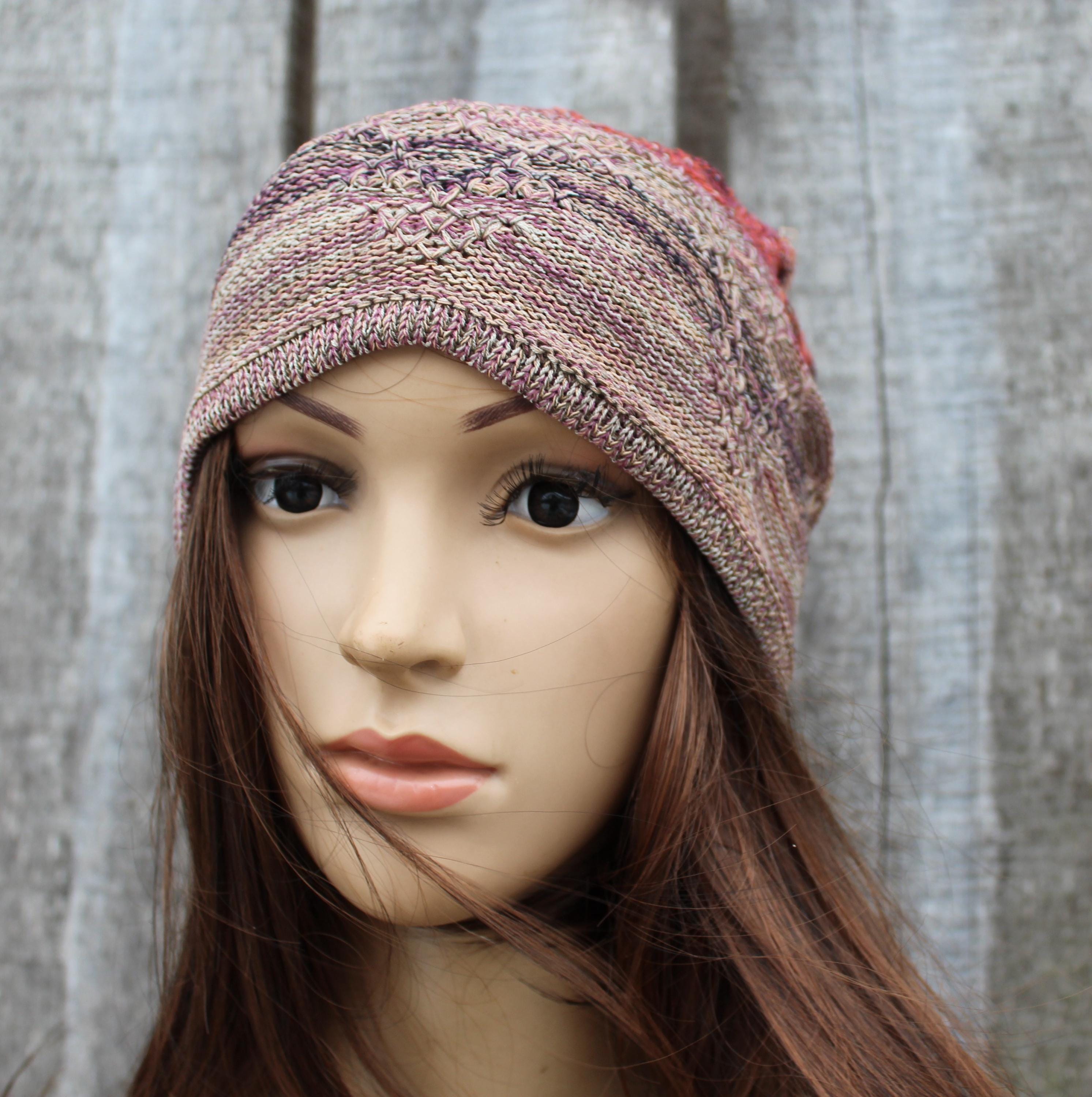 Mannequin head wearing a knitted multicolored headband against a textured gray background