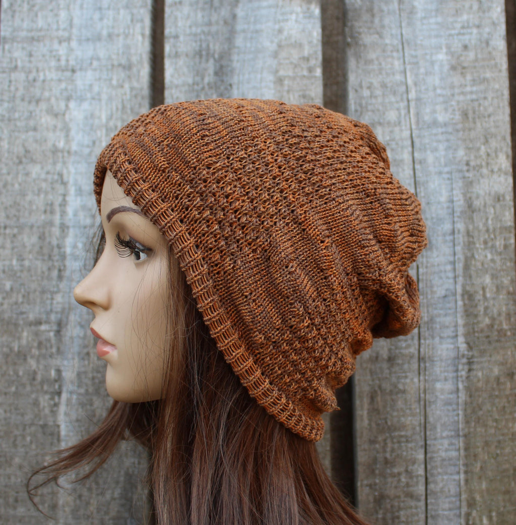 Brown knitted beanie on a mannequin head against a wooden background