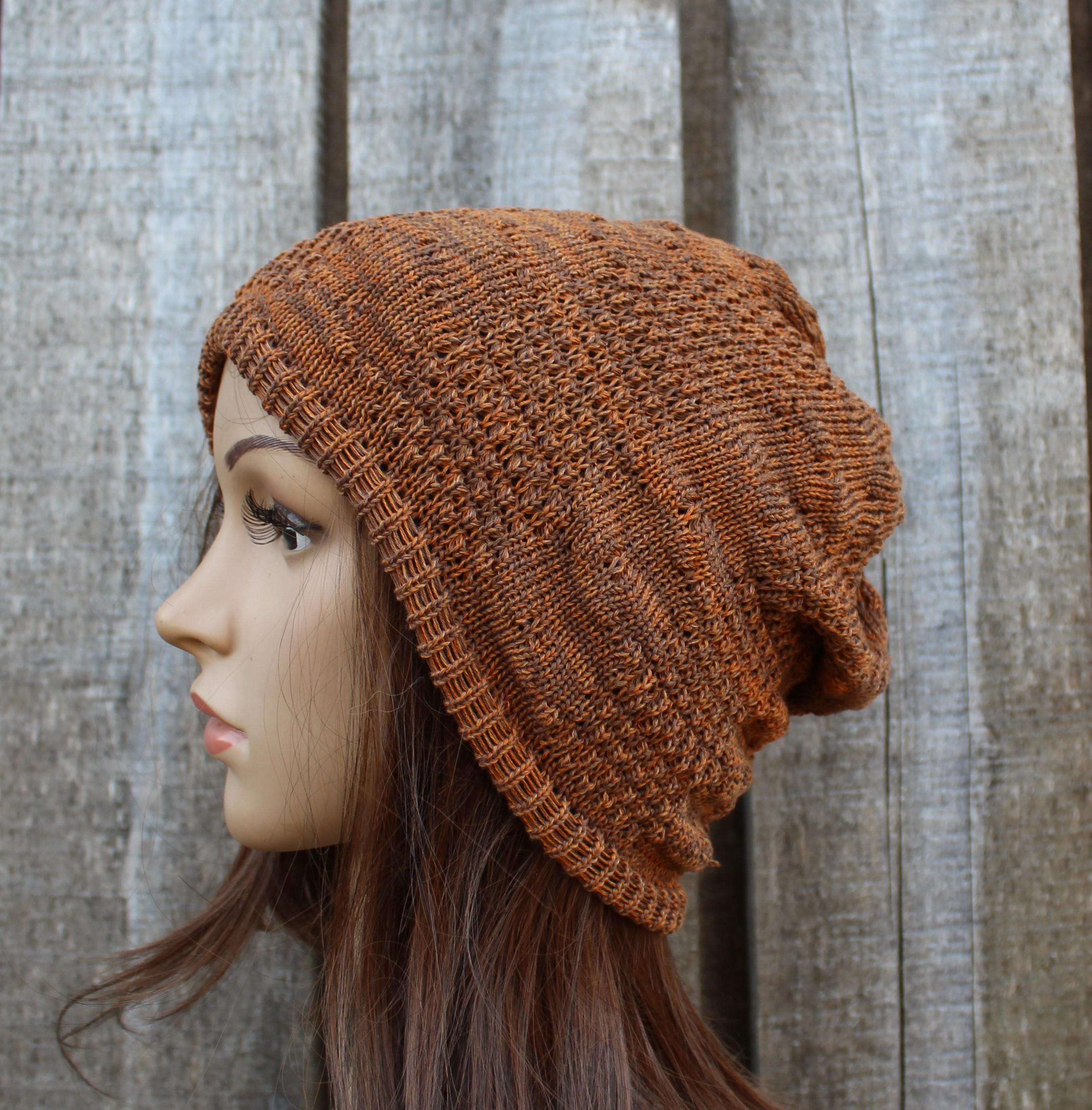 Brown knitted beanie on a mannequin head against a wooden background